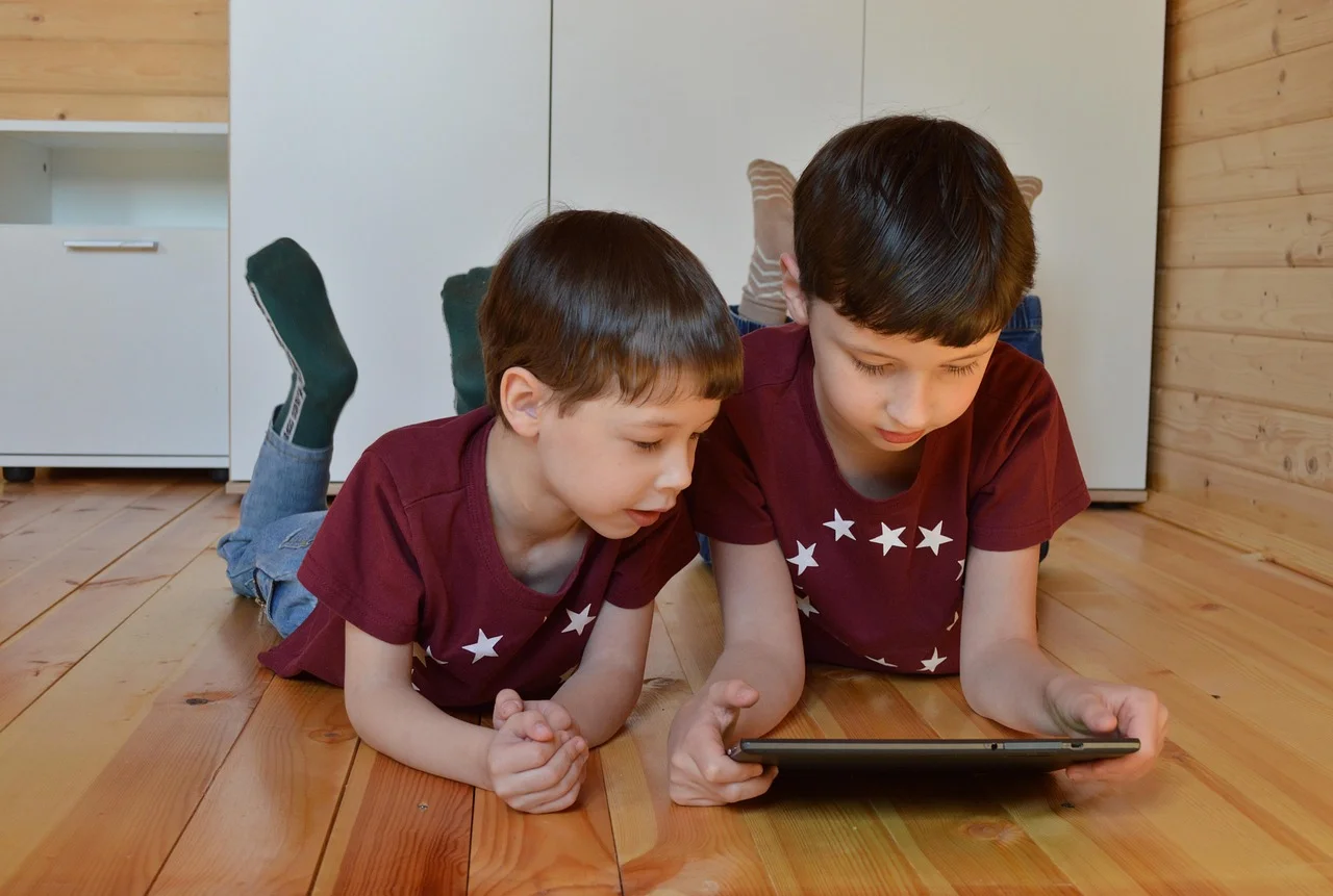 Two children looking at a tablet together