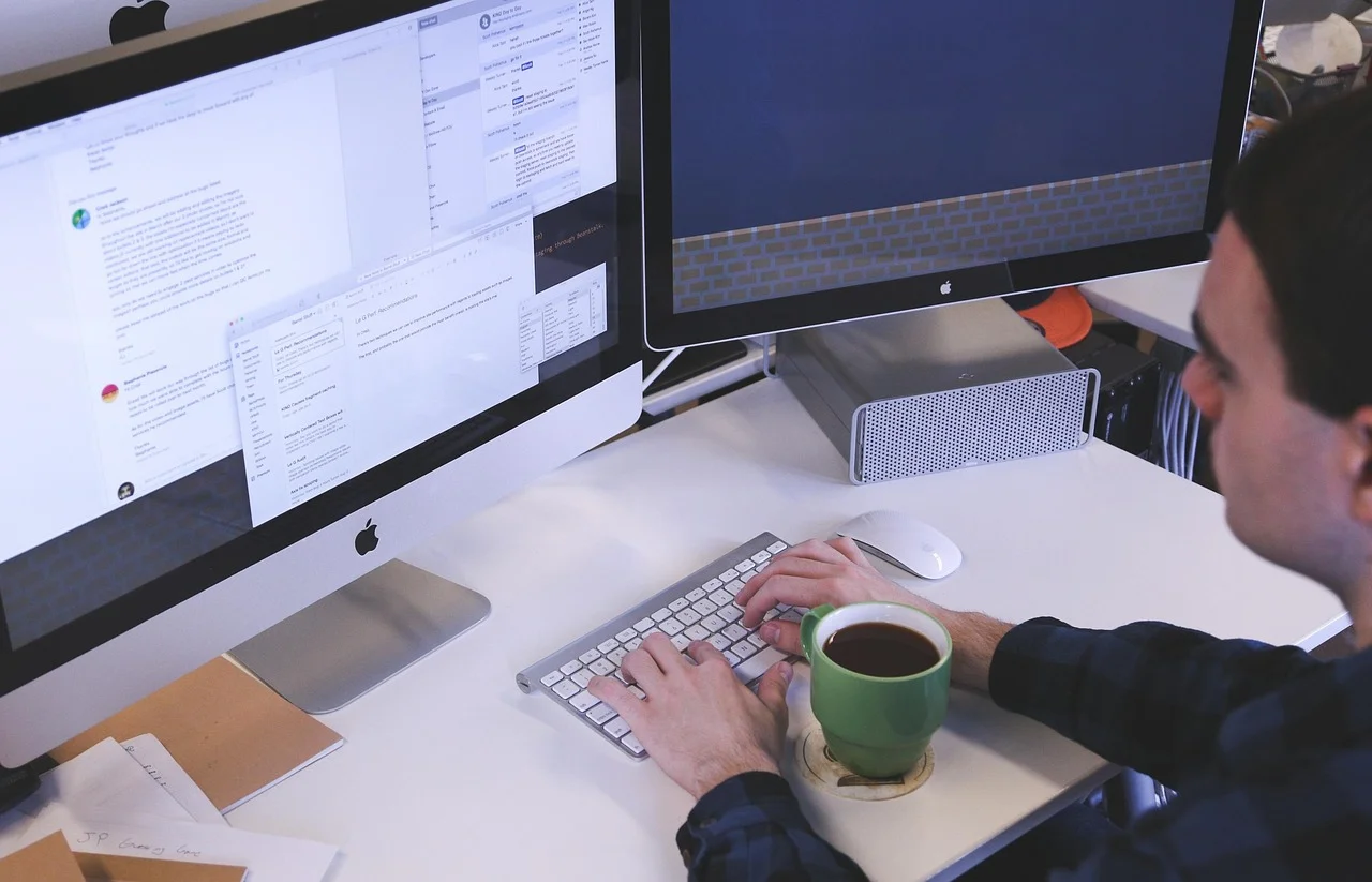 A person working at a computer and keyboard