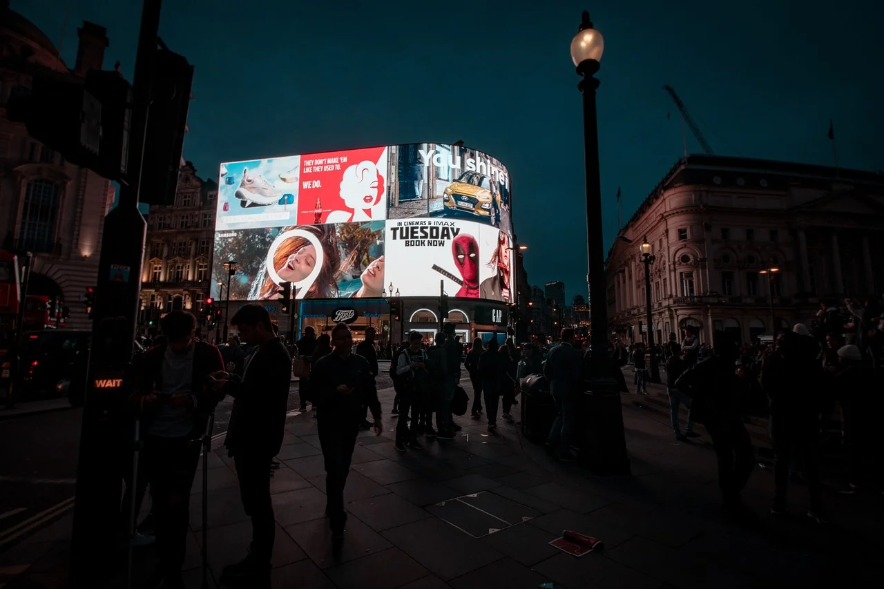 Illuminated advertising displays in a city square at night